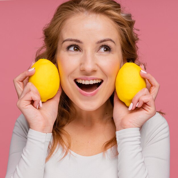 Femme en riant tenant des citrons