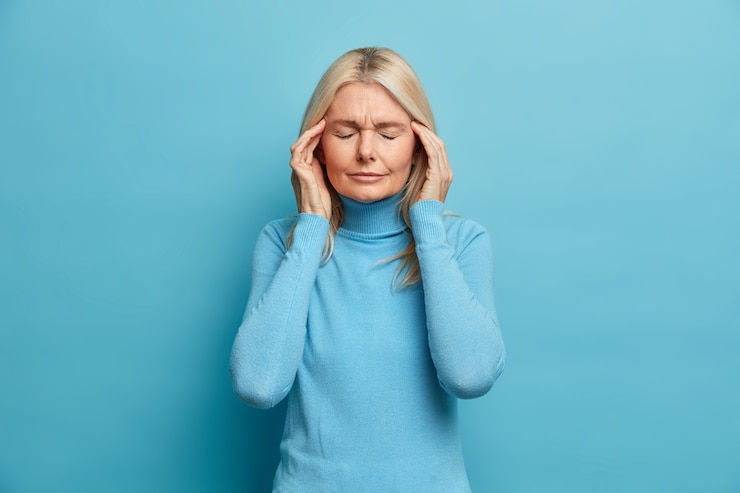 Photo gratuit femme ridée blonde stressante souffre de terribles maux de tête touche les tempes se sent désagréable ferme les yeux pour révéler la douleur