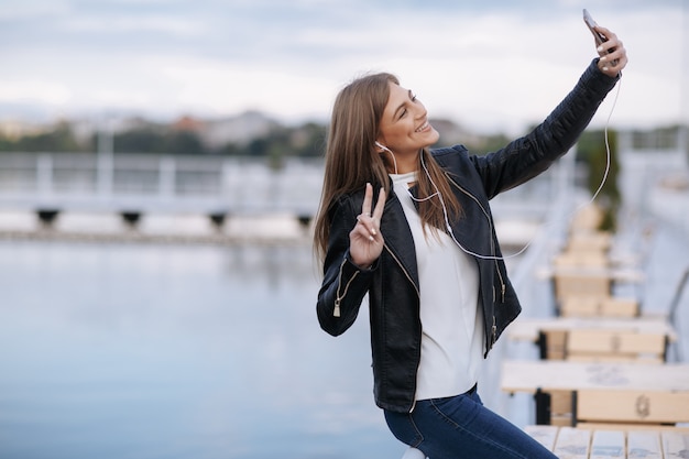 Femme rire appuyé sur une pose de garde-corps pour une photo