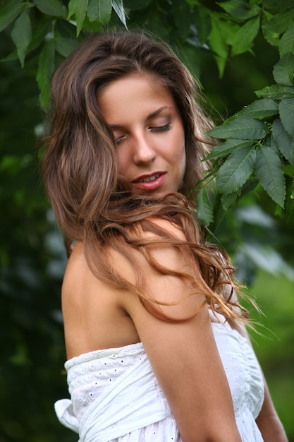 Photo gratuite femme en robe blanche avec boucles bouclées