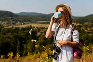 Photo gratuite femme en robe blanche, buvant à une tasse