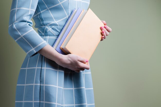 Femme avec robe bleue et deux livres