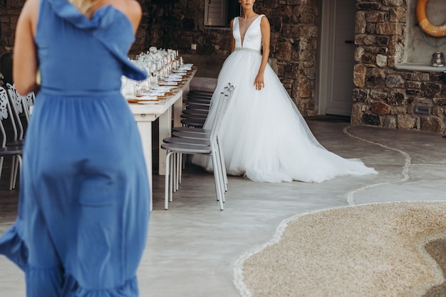 Photo gratuite femme en robe bleue se dirige vers la mariée en robe de mariée de grande classe