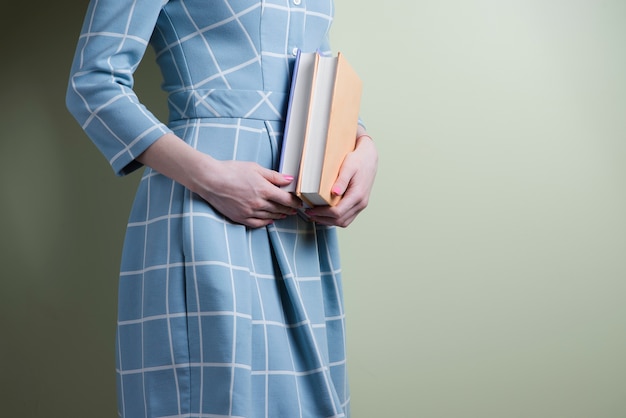 Femme avec une robe à carreaux tenant deux livres