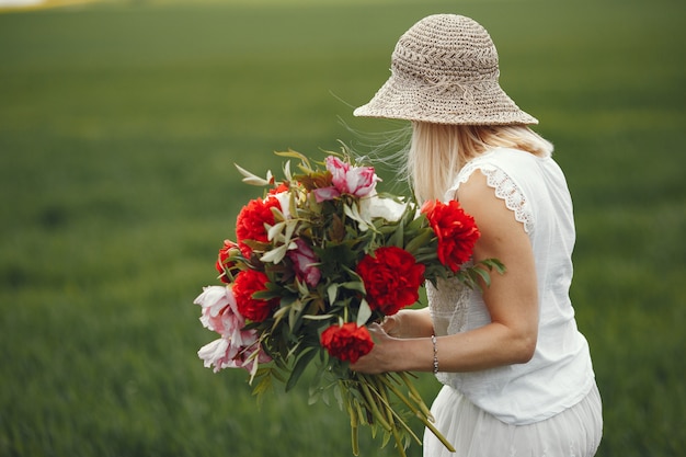 Femme en robe élégante, debout dans un champ d'été