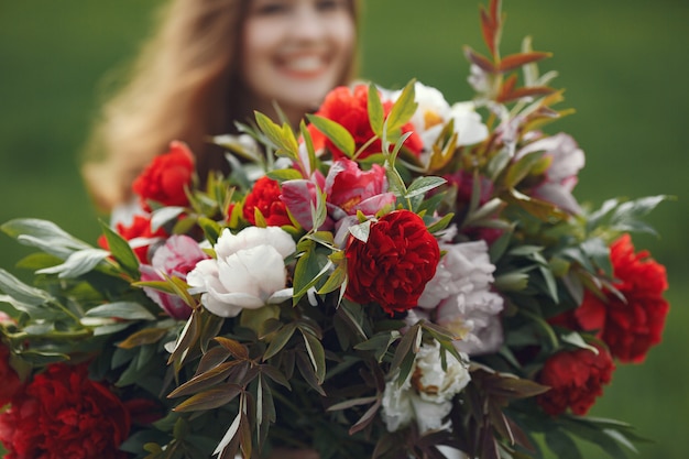 Femme en robe élégante debout dans un champ d'été