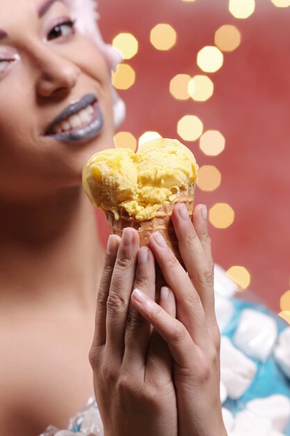 Femme en robe inhabituelle en guimauve et perruque de barbe à papa