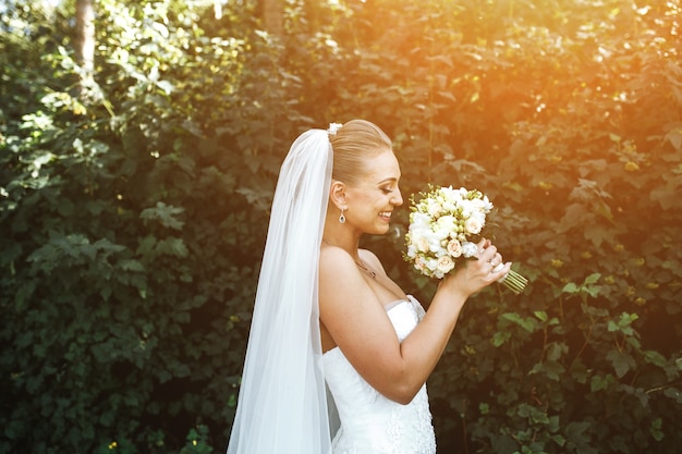 Photo gratuite femme en robe de mariée en souriant et sentir un bouquet