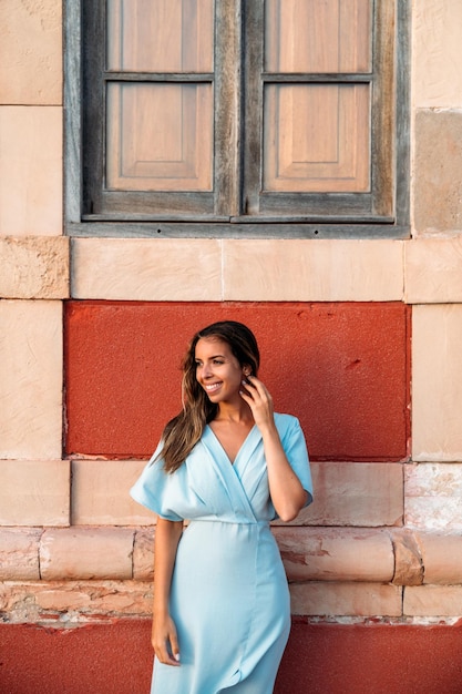 Femme en robe près du bâtiment rouge