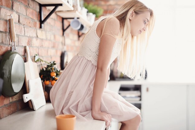 Femme avec robe s'asseoir sur la cuisine