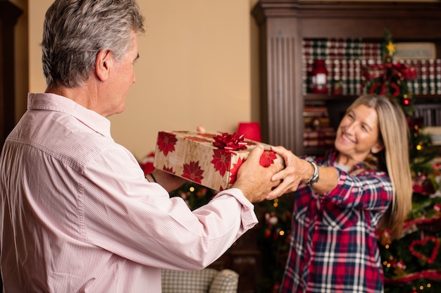 femme romantique donnant un cadeau à son mari