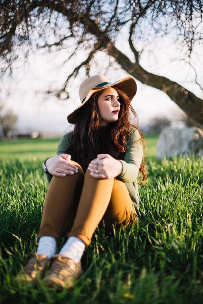 Femme romantique posant sur l&#39;herbe