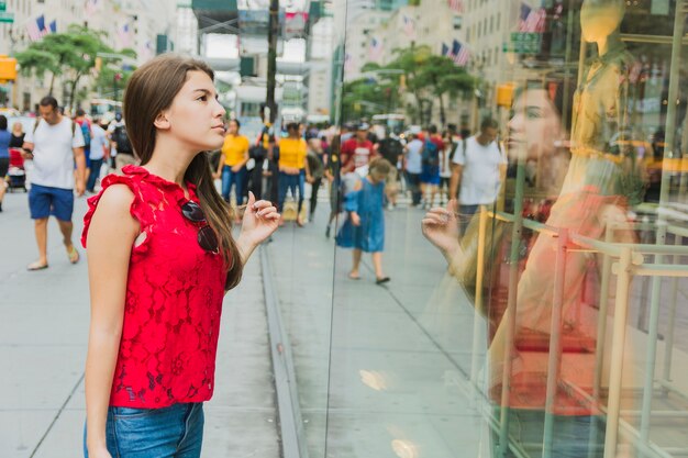 Femme en rouge regardant la vitrine