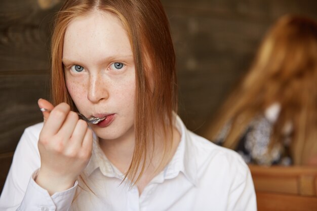 Femme rousse assise dans un café