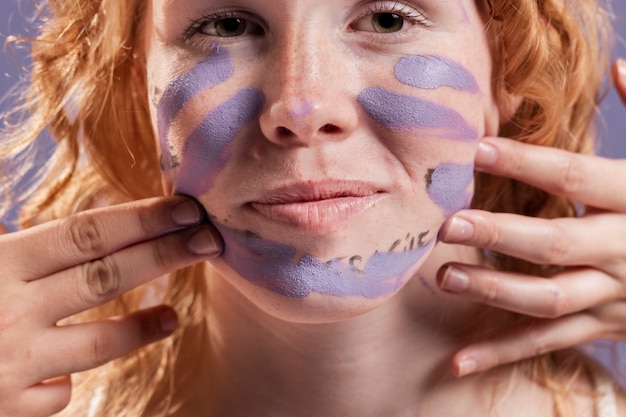 Femme rousse couverte de peinture violette