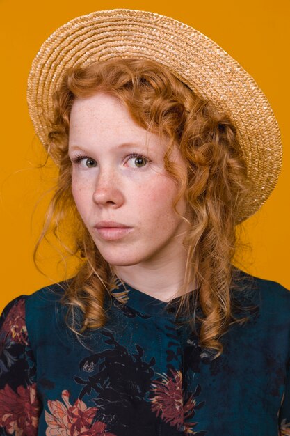 Femme rousse élégante en studio avec un arrière-plan coloré