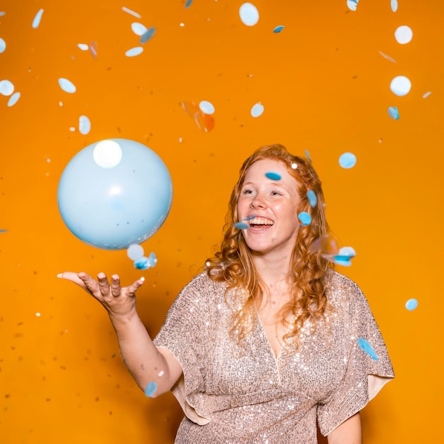 Photo gratuite femme rousse jouant avec un ballon bleu