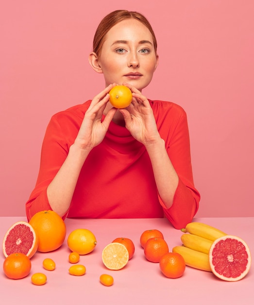 Femme rousse tenant une orange