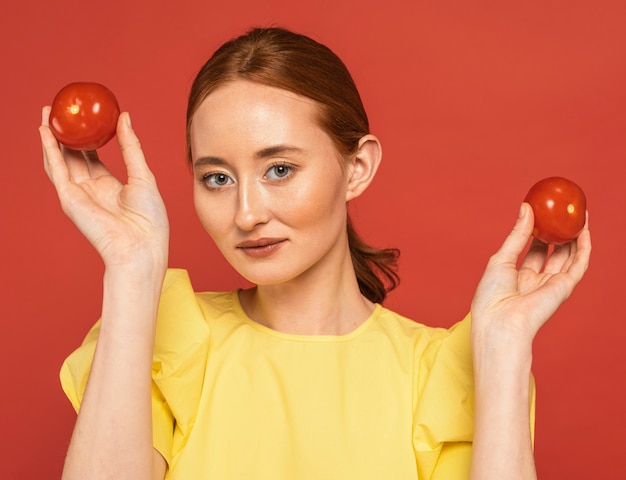 Femme rousse tenant des tomates