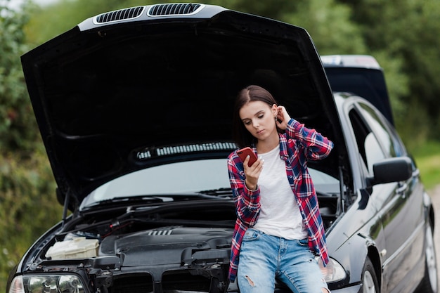 Photo gratuite femme, s'asseoir voiture, et, vérification téléphone