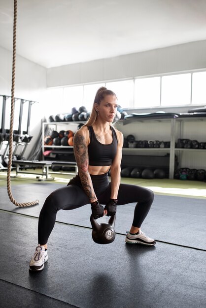 Femme s'entraînant avec kettlebell full shot