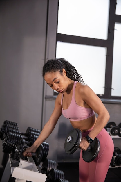 Femme s'entraînant pour l'haltérophilie dans la salle de sport