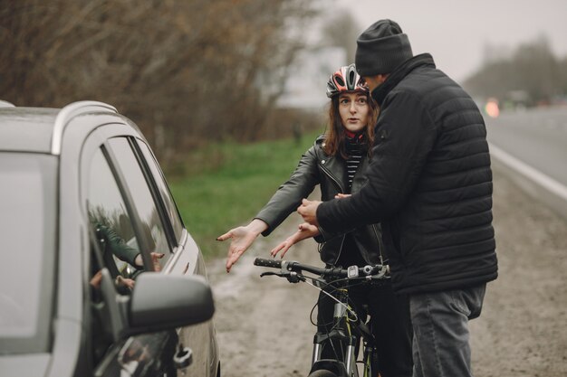 La femme s'est écrasée dans la voiture. Fille dans un casque. Les gens se disputent l'accident.