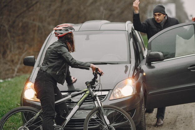 La femme s'est écrasée dans la voiture. Fille dans un casque. Les gens se disputent l'accident.