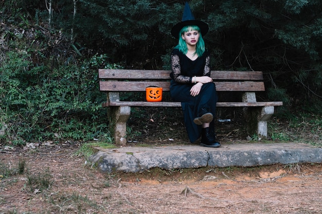 Femme avec sac de citrouille sur le banc