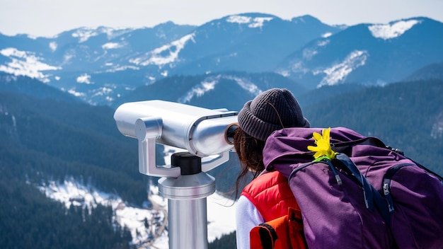 Femme avec sac à dos au sommet de la montagne regardant la nature