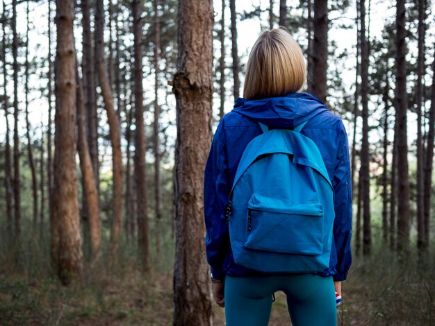 Femme avec sac à dos en forêt