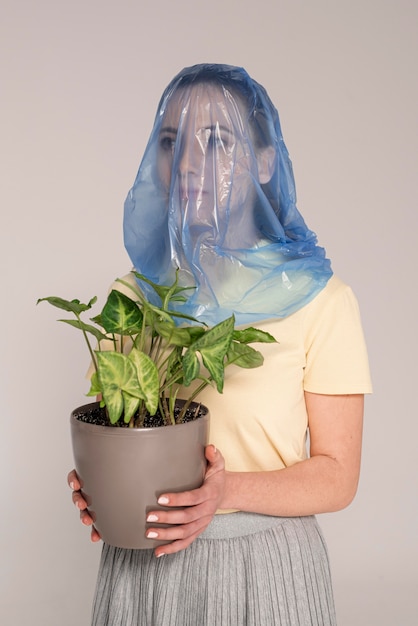 Photo gratuite femme avec sac en plastique sur la tête de pot de fleur pliant
