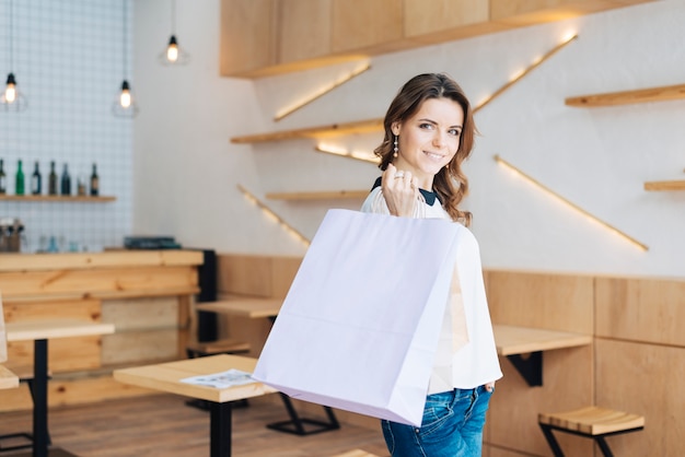 Femme avec des sacs en papier au café