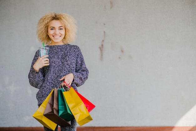 Photo gratuite femme avec des sacs en papier et des boissons