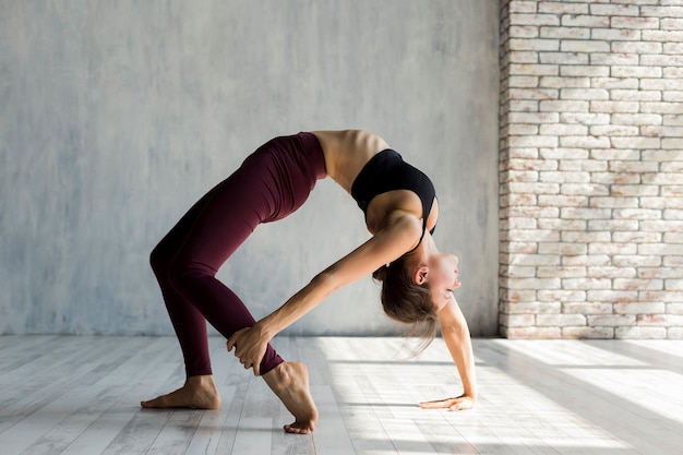 Femme, saisir, son pied, debout, dans, a, pont, pose yoga