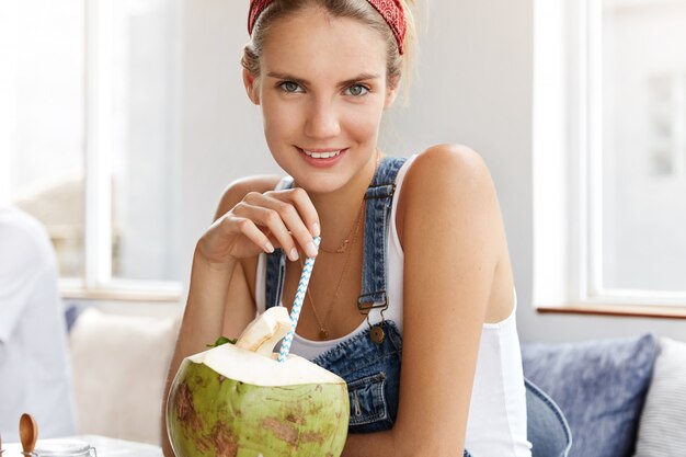 Femme en salopette en denim élégant dans un café