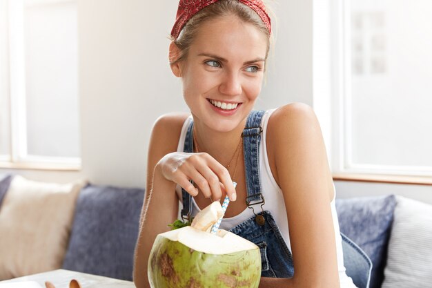 Femme en salopette en denim élégant dans un café