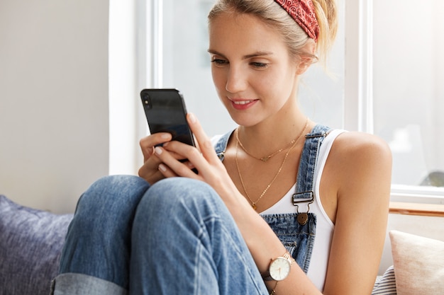 Femme en salopette en denim élégant dans un café