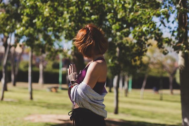 Femme sans visage méditant dans le parc