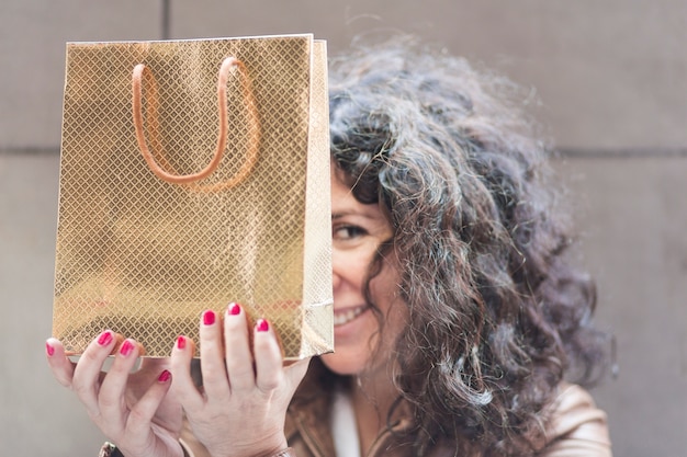 Photo gratuite femme se cachant avec un sac à provisions