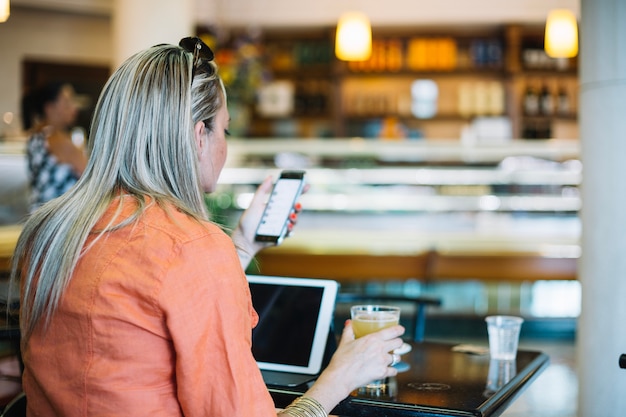 Femme se détendre au café avec des gadgets