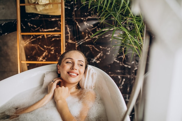 Femme se détendre dans le bain avec des bulles