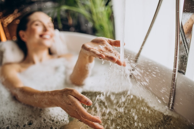 Femme se détendre dans le bain avec des bulles