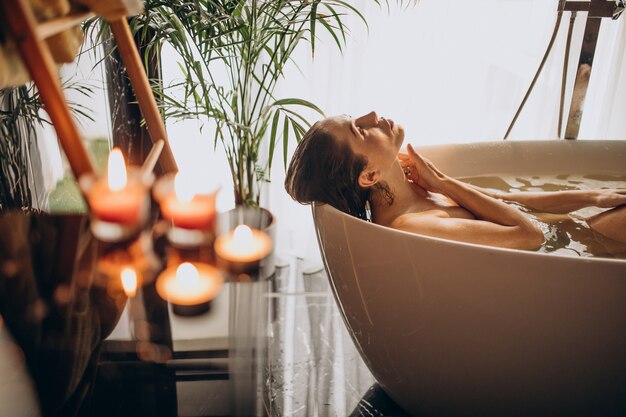 Femme se détendre dans le bain avec des bulles