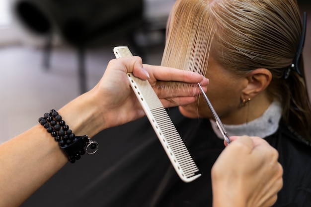 Femme se faisant couper les cheveux au salon de beauté