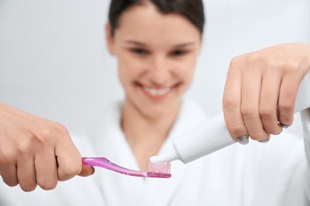 Femme se préparant à nettoyer les dents à la maison