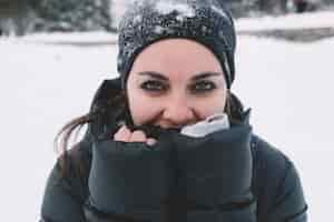 Photo gratuite femme se réchauffant les mains sur fond neigeux