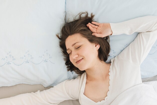 Femme se relaxant dans son lit