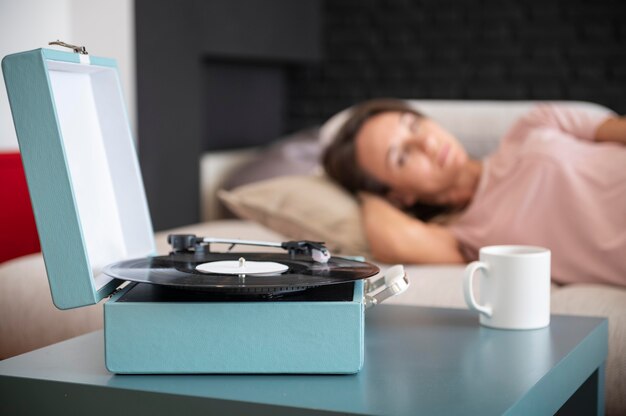 Femme se relaxant à la maison tout en écoutant de la musique vinyle