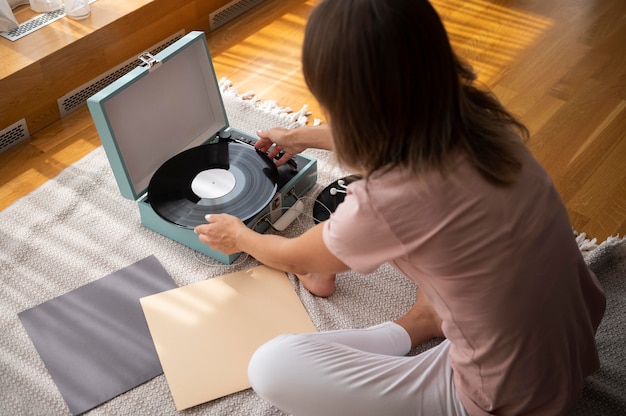 Femme se relaxant tout en écoutant de la musique à la maison